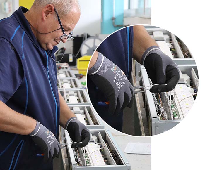 Mitarbeiter von Kontaktsysteme GmbH verdrahtet die elektronischen Komponenten, Klemmen und Steckverbinder